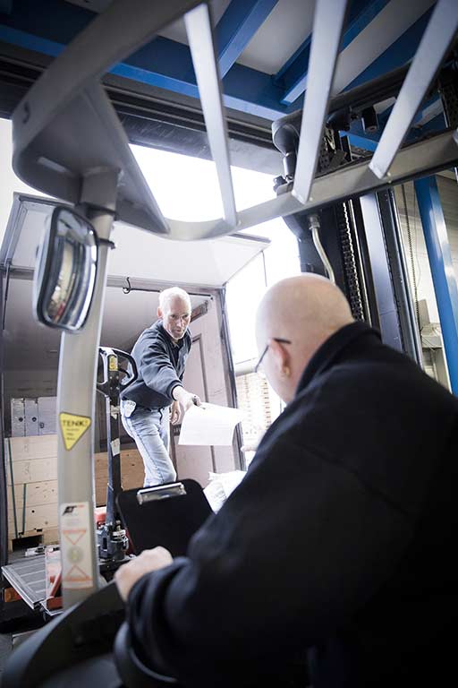 To menn laster varer i en varebil